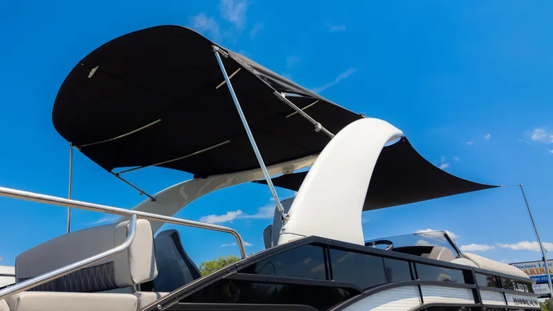 Slide: The Image of 2022 Bennington 24 LXSBA boat with canopy against clear blue sky. - 33