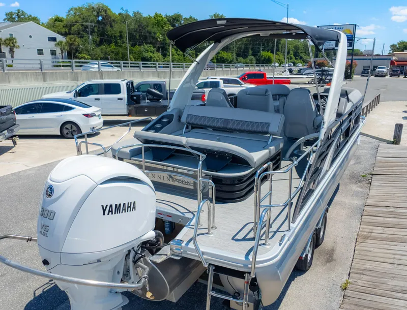 Slide: The Image of 2022 Bennington 24 LXSBA pontoon boat with Yamaha V6 engine, parked on a sunny day. - 6