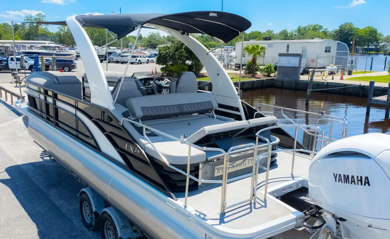 Slide: The Image of 2022 Bennington 24 LXSBA pontoon boat with Yamaha engine, docked near a marina. - 8