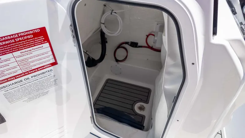 Slide: The Image of Open storage compartment on 2025 Tidewater 2110 Bay Max boat with safety instructions. - 14