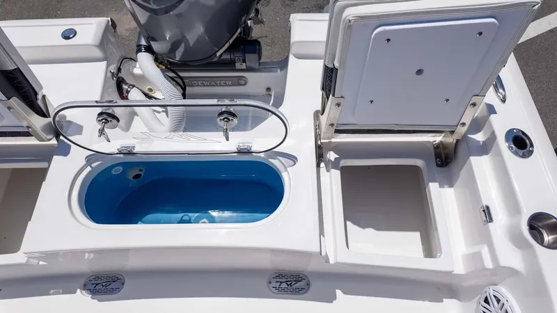 Slide: The Image of 2025 Tidewater 2110 Bay Max boat with open storage compartments and livewell. - 7