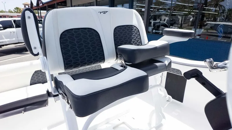 Slide: The Image of 2025 Tidewater 220LXF boat seating with black and white upholstery, outdoor showroom display. - 12
