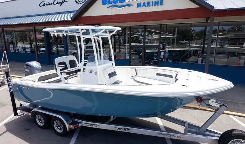 Slide: The Image of 2025 Tidewater 220LXF boat on trailer outside Bluewater Marine dealership. - 3