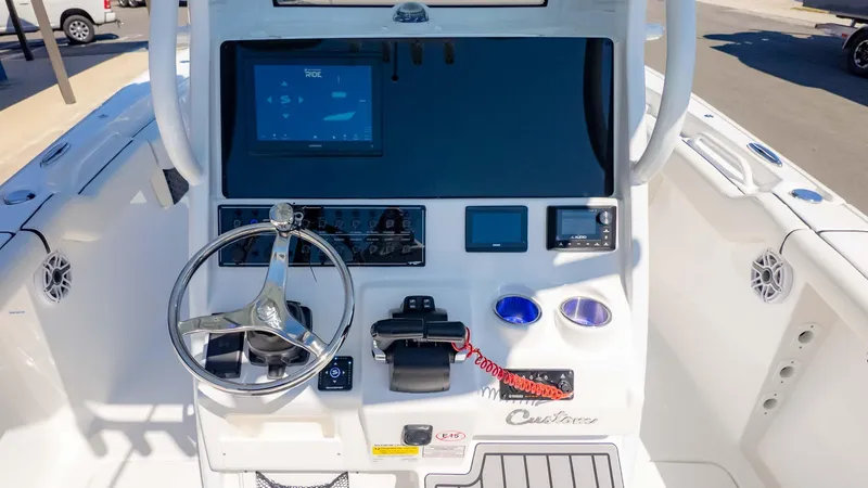 Slide: The Image of 2025 Tidewater 256CC boat dashboard with steering wheel, digital displays, and controls. - 14