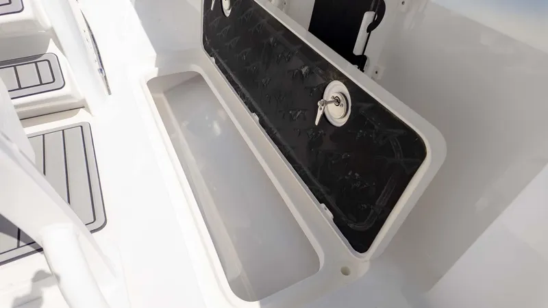 Slide: The Image of 2025 Tidewater 256CC boat storage compartment with secure lock and sleek design. - 16