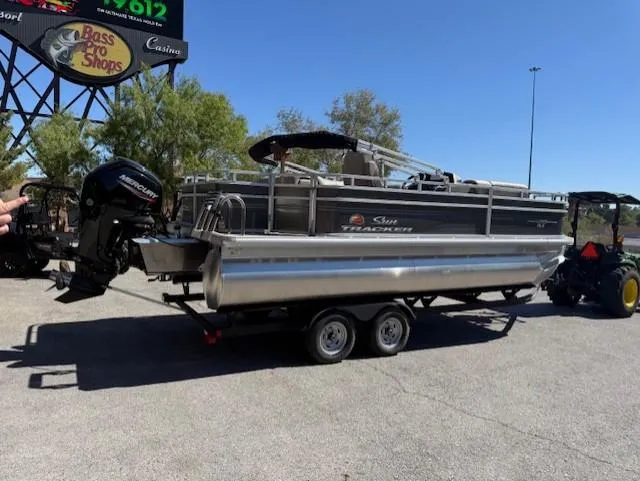 Slide: The Image of 2025 Sun Tracker Fishin' Barge 20 DLX pontoon boat on trailer, outdoor setting. - 3