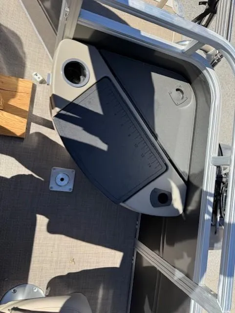 Slide: The Image of Interior view of 2025 Sun Tracker Fishin' Barge 20 DLX boat, featuring a cup holder and storage area. - 9