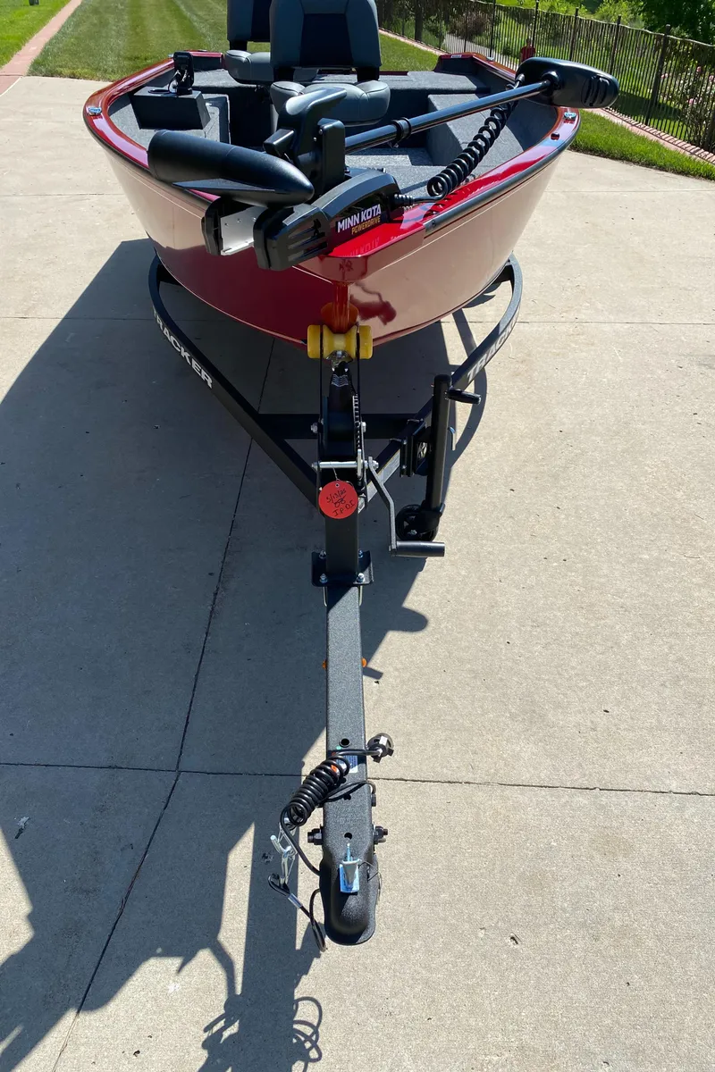 Slide: The Image of 2025 Tracker Super Guide V-16 T boat on trailer, parked on concrete driveway. - 2