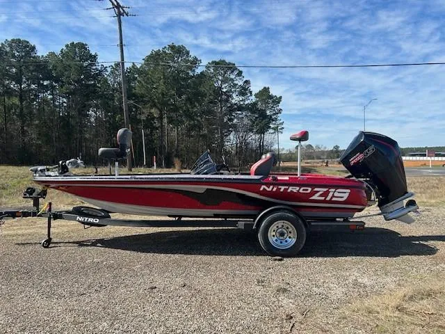 Slide: The Image of 2025 Nitro Z19 boat on trailer, red and black design, parked outdoors. - 1