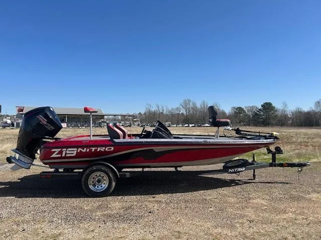 Slide: The Image of 2025 Nitro Z19 boat on trailer in open field under clear blue sky. - 20