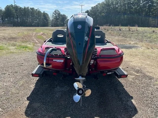 Slide: The Image of 2025 Nitro Z19 boat, rear view, red color, parked on gravel with trees in background. - 7