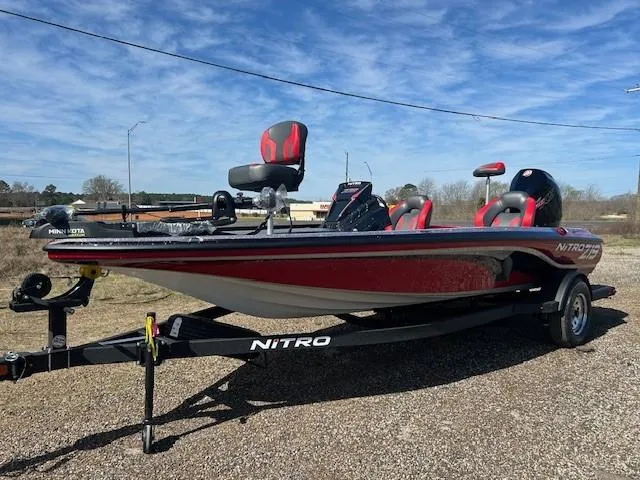 Slide: The Image of 2025 Nitro Z19 boat on trailer, red and black design, parked outdoors. - 9