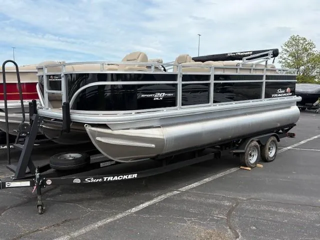 The Image of 2025 Sun Tracker SportFish 20 DLX pontoon boat on trailer in parking lot. - 0