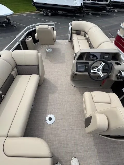 Slide: The Image of 2025 Sun Tracker SportFish 20 DLX pontoon boat interior with beige seating and steering console. - 2