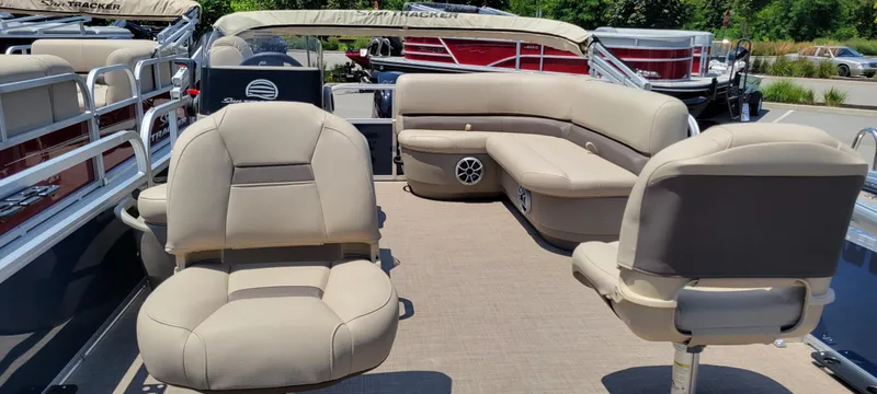 Slide: The Image of 2025 Sun Tracker Party Barge 18 DLX with beige seating and spacious deck layout. - 2