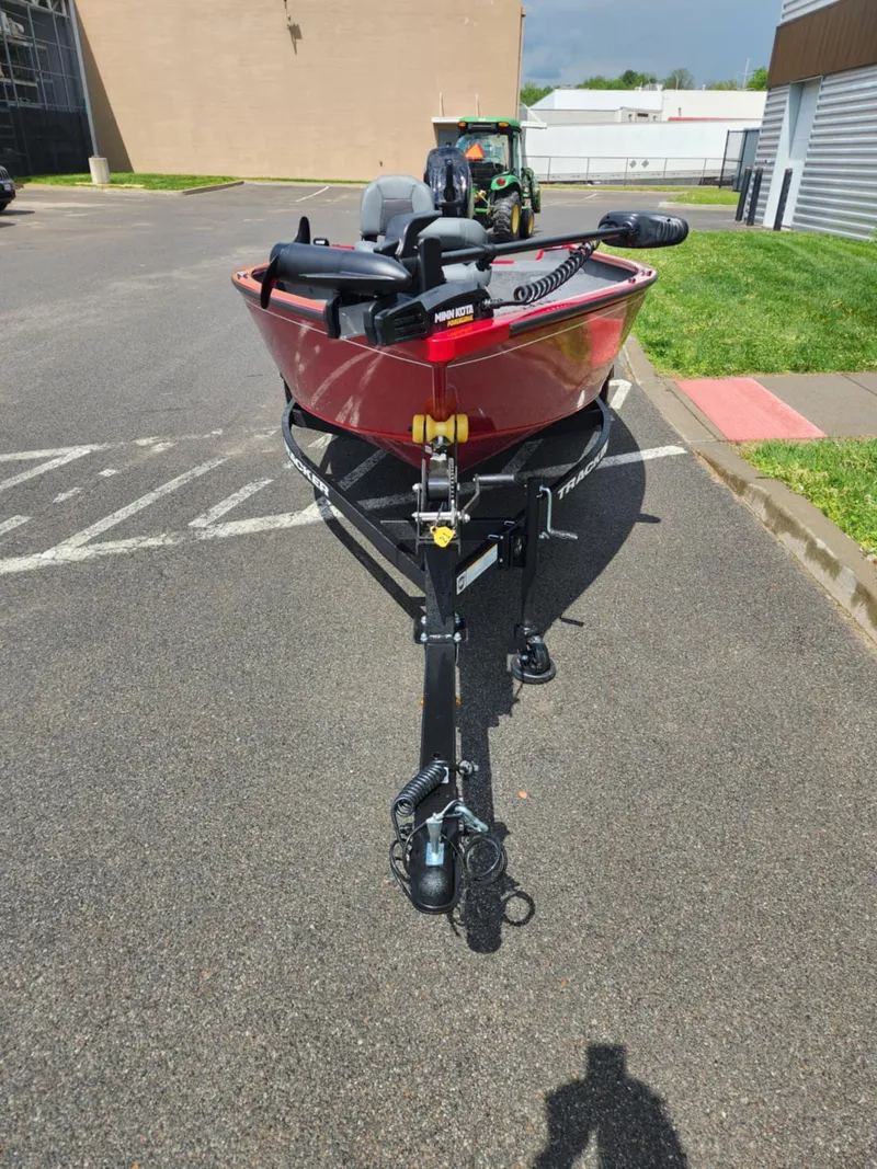 Slide: The Image of 2025 Tracker Super Guide V-16 T boat on trailer in parking lot. - 2