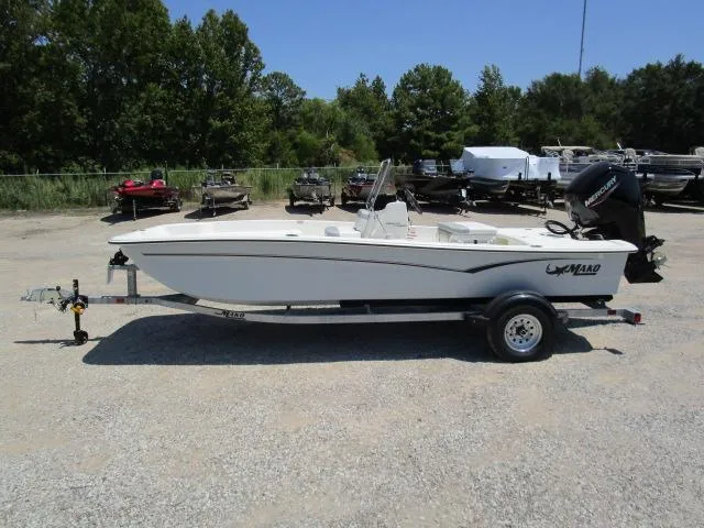 Slide: The Image of 2023 Mako Pro Skiff 17 CC boat on trailer, parked outdoors, surrounded by trees and other boats. - 7