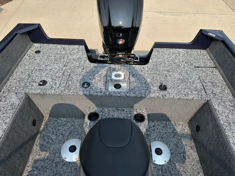 Slide: The Image of 2025 Tracker Pro Guide V-175 WT boat interior with motor, featuring gray carpeted deck. - 9