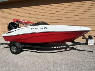 The Image of 2025 Tahoe T16 boat with red hull on trailer, parked outdoors. - 0