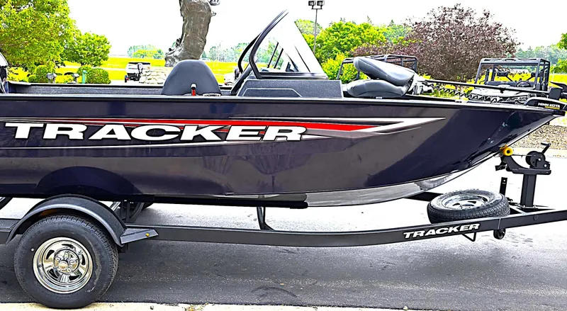 Slide: The Image of 2025 Tracker Pro Guide V-175 Combo boat on trailer, parked outdoors. - 5