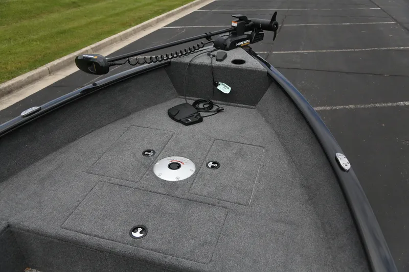 Slide: The Image of 2025 Tracker Super Guide V-16 T boat deck with trolling motor in parking lot. - 2