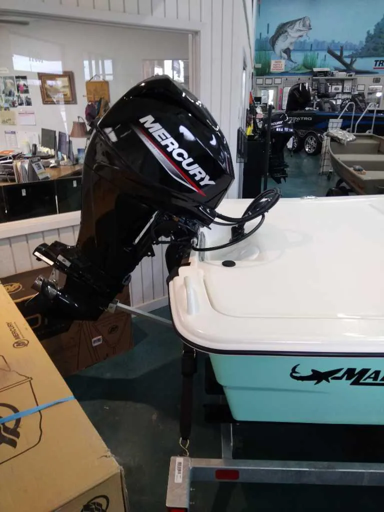 Slide: The Image of 2024 Mako Pro Skiff 13 CC with Mercury outboard motor in showroom. - 4