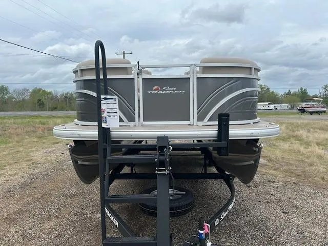 Slide: The Image of 2025 Sun Tracker Party Barge 22 DLX pontoon boat on trailer, parked outdoors. - 15