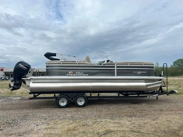 Slide: The Image of 2025 Sun Tracker Party Barge 22 DLX pontoon boat on trailer, parked outdoors. - 4
