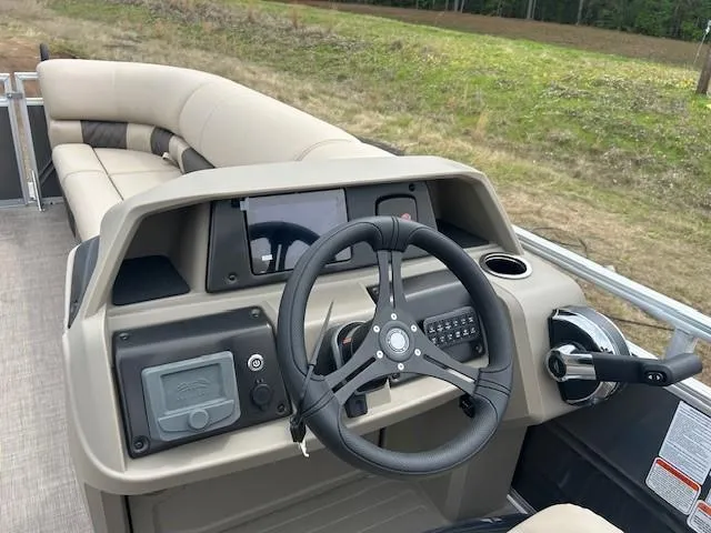 Slide: The Image of 2025 Sun Tracker Party Barge 22 DLX interior with steering wheel and seating. - 5