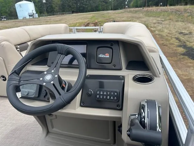 Slide: The Image of 2025 Sun Tracker Party Barge 22 DLX dashboard with steering wheel and control panel. - 6