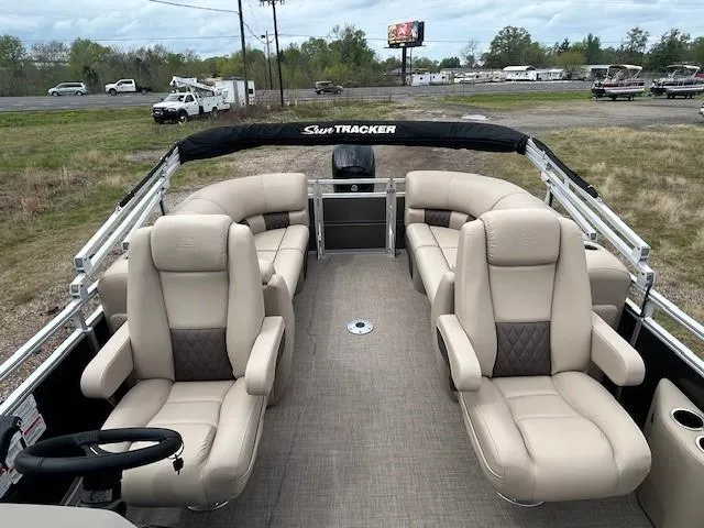 Slide: The Image of 2025 Sun Tracker Party Barge 22 DLX with beige seating, outdoor setting, and spacious deck. - 9