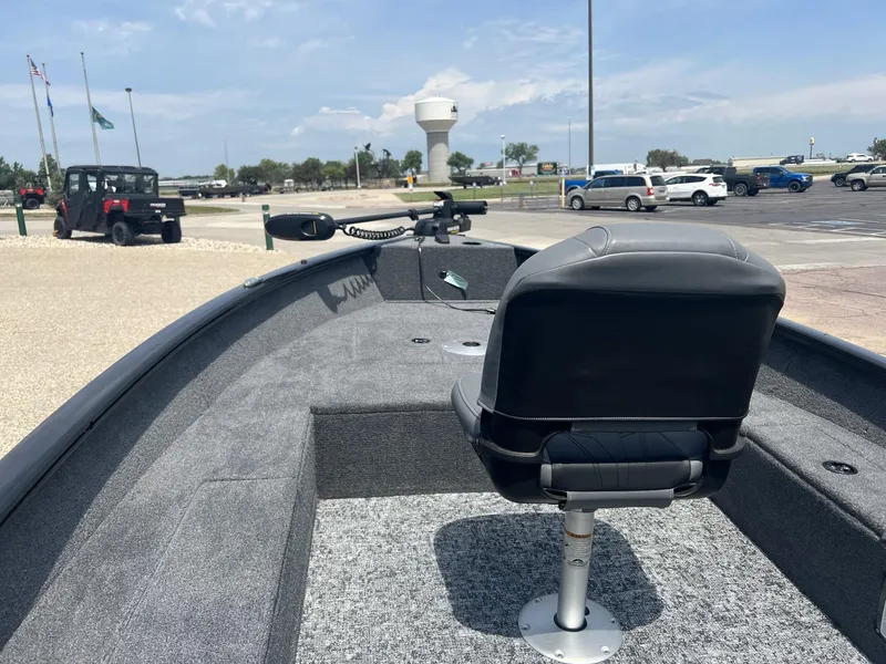 Slide: The Image of 2025 Tracker Super Guide V-16 T boat interior with seating, parked in a lot. - 3