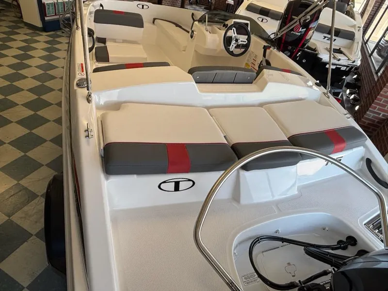 Slide: The Image of 2025 Tahoe T16 boat interior with red and gray seating, steering wheel, and checkered floor. - 3