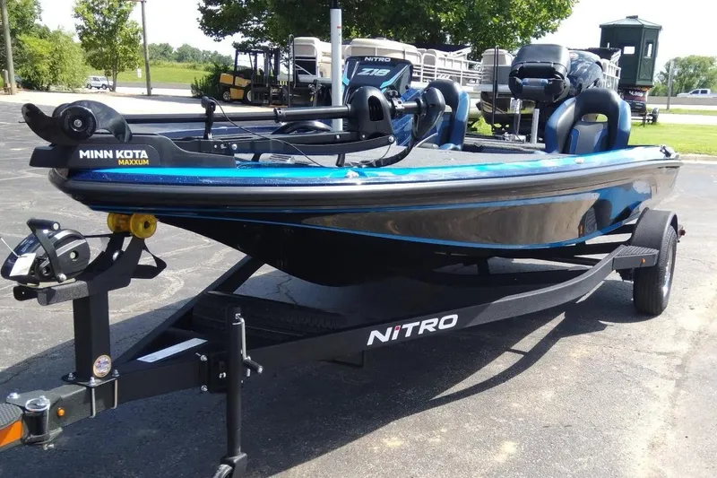 Slide: The Image of 2025 Nitro Z18 boat on trailer with Minn Kota Maxxum motor, parked outdoors. - 1