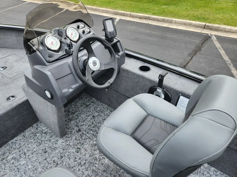 Slide: The Image of 2025 Tracker Super Guide V-16 SC boat interior with steering console and seating. - 2