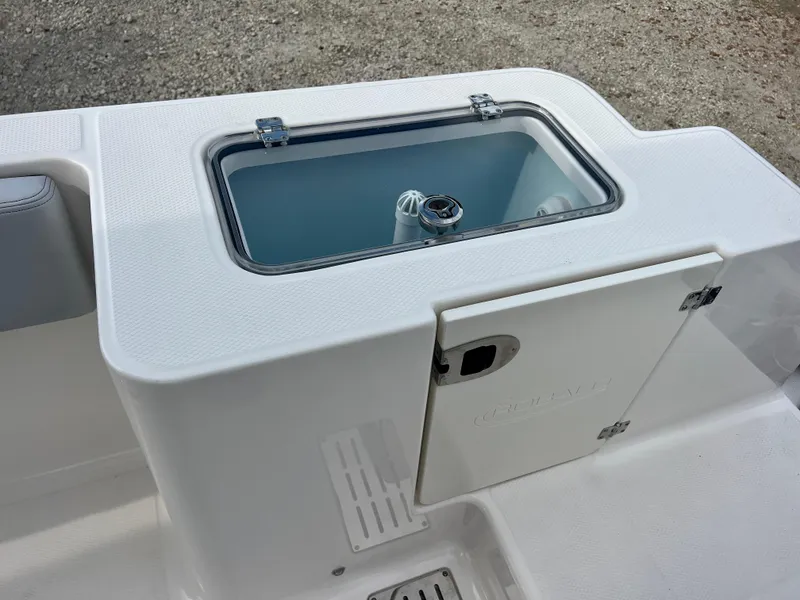 Slide: The Image of 2025 Robalo R300 boat livewell and storage compartment, featuring a sleek white design. - 19