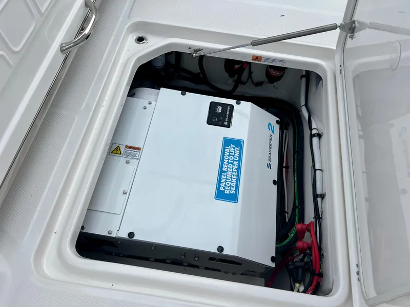 Slide: The Image of 2025 Robalo R300 boat storage compartment with electrical equipment and wiring. - 21