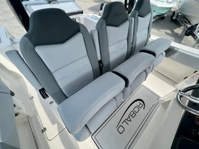 Slide: The Image of 2025 Robalo R300 boat interior with sleek, modern seating and branded floor mat. - 23