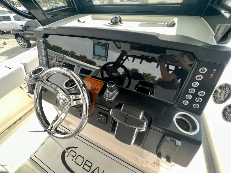 Slide: The Image of 2025 Robalo R300 boat dashboard with steering wheel, controls, and digital display. - 24