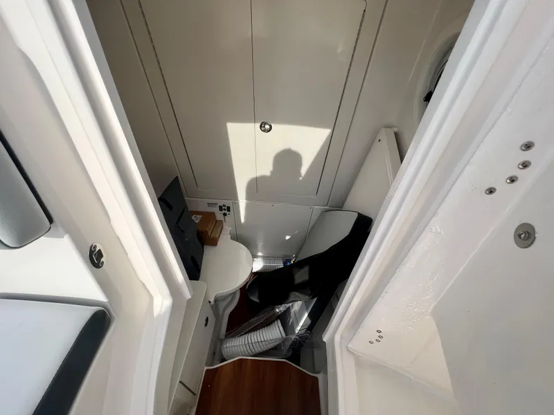 Slide: The Image of 2025 Robalo R300 boat interior with compact bathroom and modern design. - 32