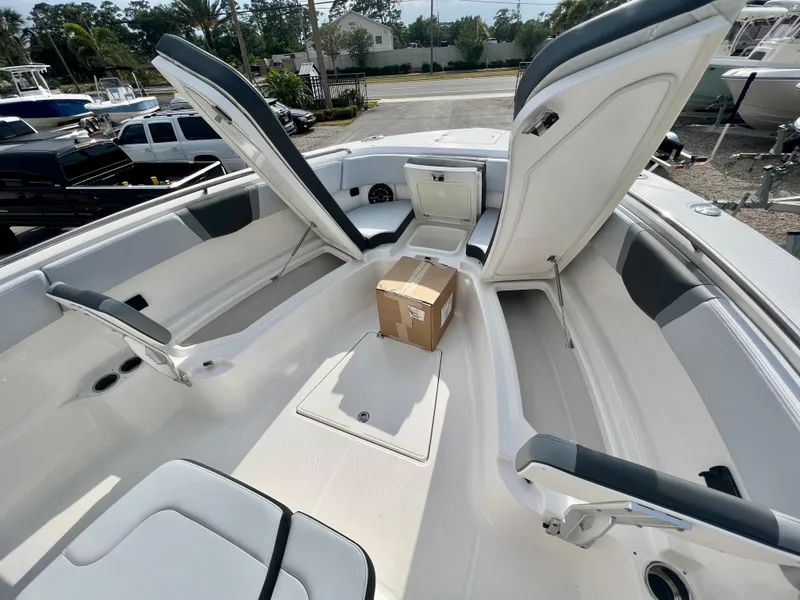 Slide: The Image of 2025 Robalo R300 boat interior with open storage compartments and a package on deck. - 34