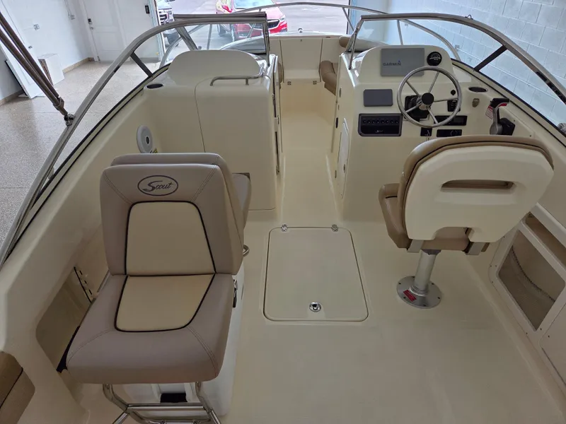Slide: The Image of Interior view of a 2017 Scout 225 Dorado boat, featuring beige seating and steering console. - 10