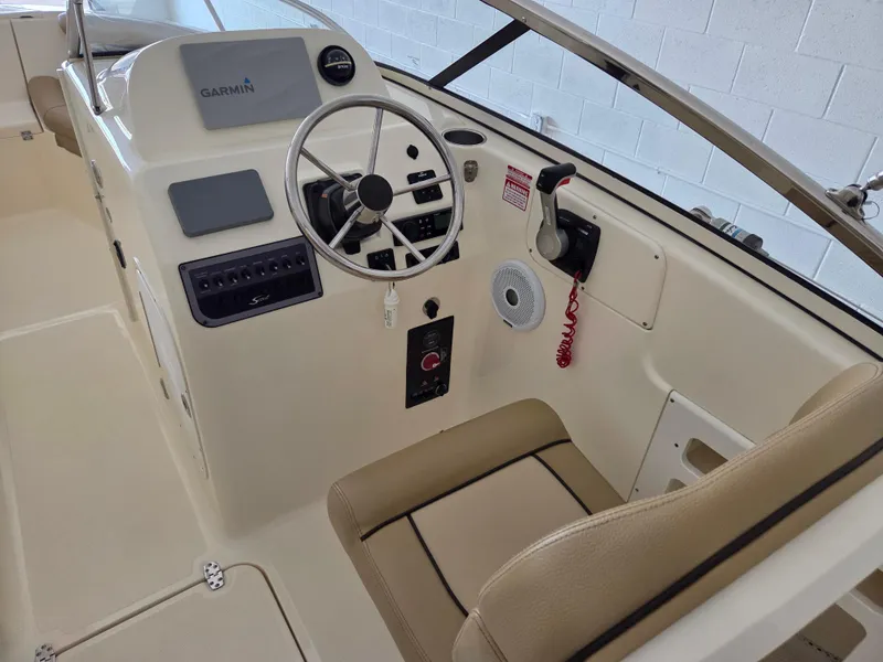 Slide: The Image of 2017 Scout 225 Dorado boat cockpit with Garmin navigation system and beige seating. - 11