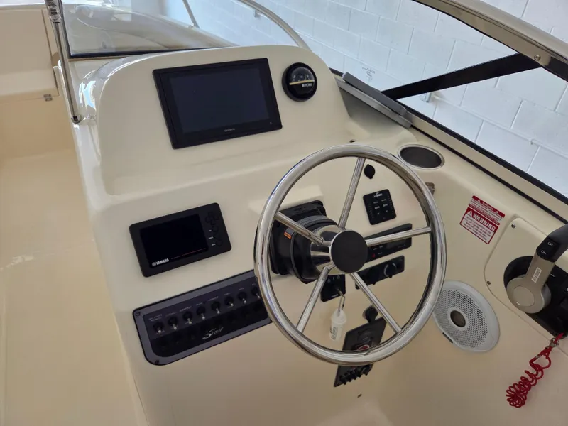 Slide: The Image of 2017 Scout 225 Dorado boat dashboard with steering wheel and electronic controls. - 12