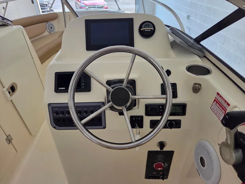 Slide: The Image of 2017 Scout 225 Dorado boat helm with steering wheel and control panel. - 13