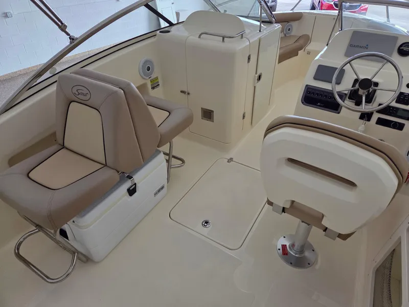 Slide: The Image of 2017 Scout 225 Dorado boat interior with beige seating and steering console. - 14