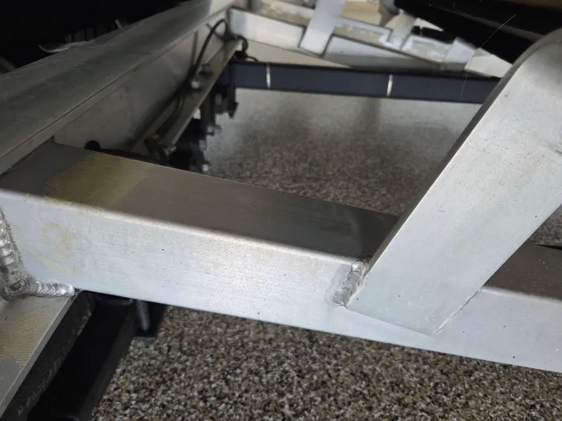 Slide: The Image of Close-up of a 2017 Scout 225 Dorado boat trailer frame on a speckled floor. - 33