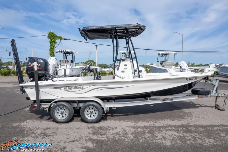 Slide: The Image of 2016 Blue Wave 2200 STL boat on trailer, parked outdoors under clear sky. - 11