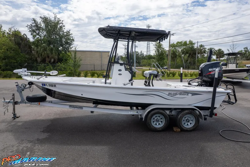 Slide: The Image of 2016 Blue Wave 2200 STL boat on trailer, parked outdoors. - 2