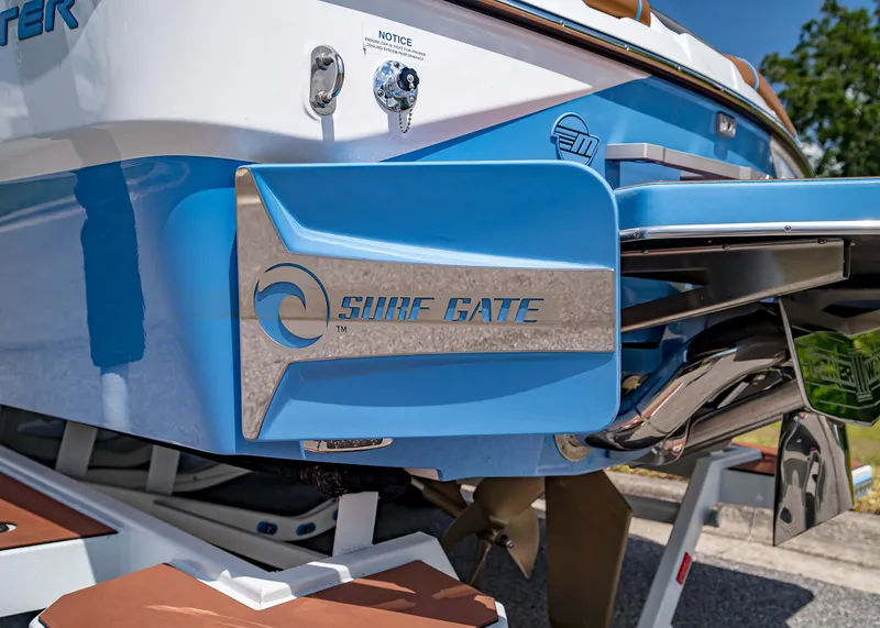 Slide: The Image of 2024 Malibu Wakesetter 24 MXZ with Surf Gate feature, blue and white design. - 12